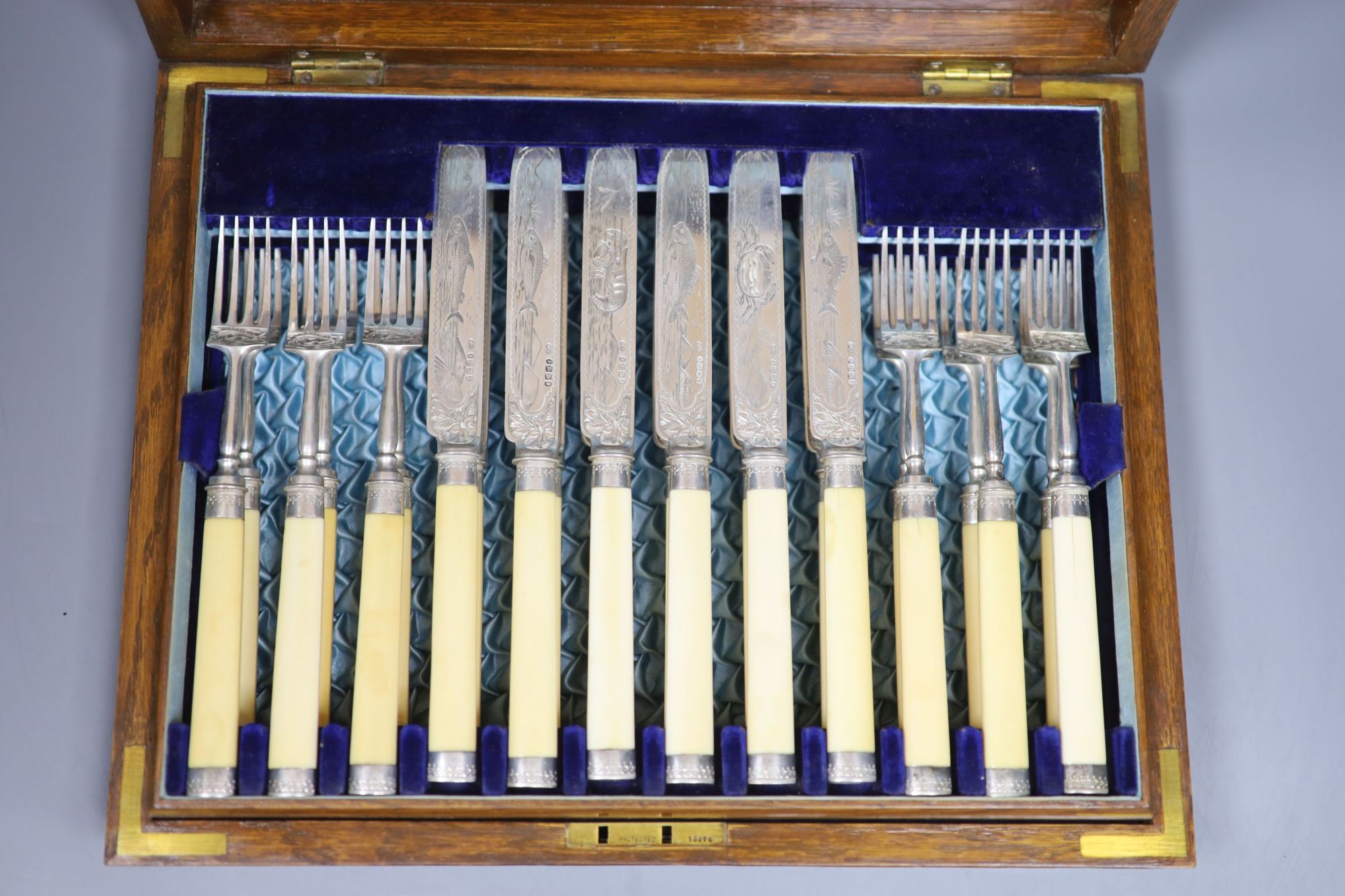 A Victorian oak cased set of twelve pairs of ivory handled silver dessert eaters, Frederick Elkington, Birmingham, 1890, box 34.8cm.